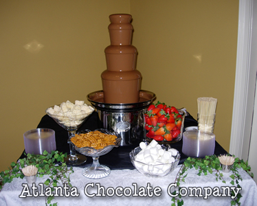 ATLANTA CHOCOLATE FOUNTAIN RENTAL 27 inch chocolate fountain with milk chocolate and an array of dipping items in a casual setting -image